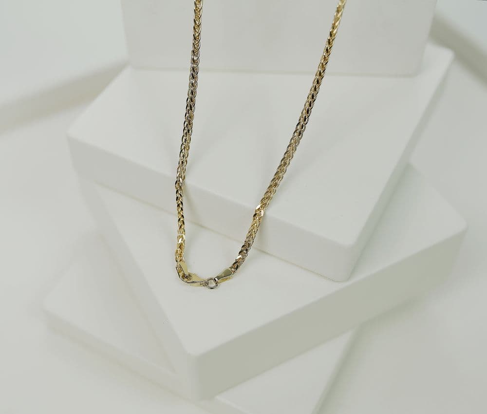Illustrative gold necklace on a display bust