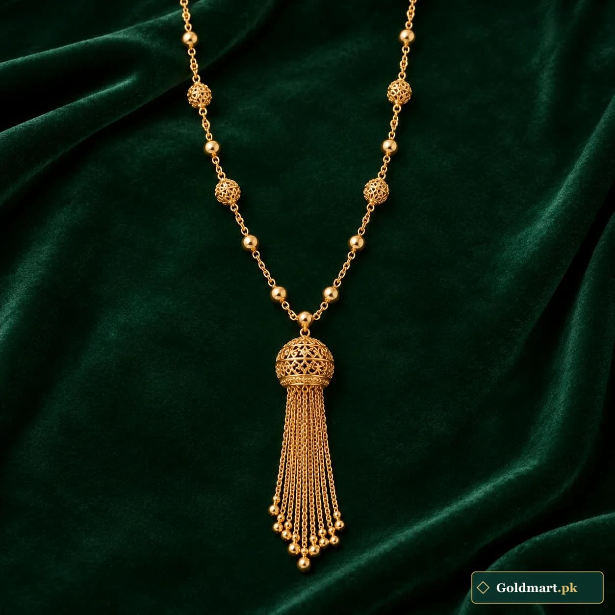 Afreen Tassel Necklace: a long gold-tone necklace with a rounded filigree cap and fine chain tassel pendant