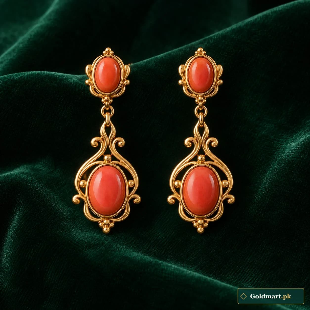 Isha Coral-Accent Earrings: a pair of gold-tone drop earrings with coral-coloured oval accents and small scroll surrounds